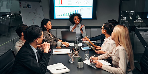 group-analyzing-work-data-in-meeting-room / two-people-going-over-business-data